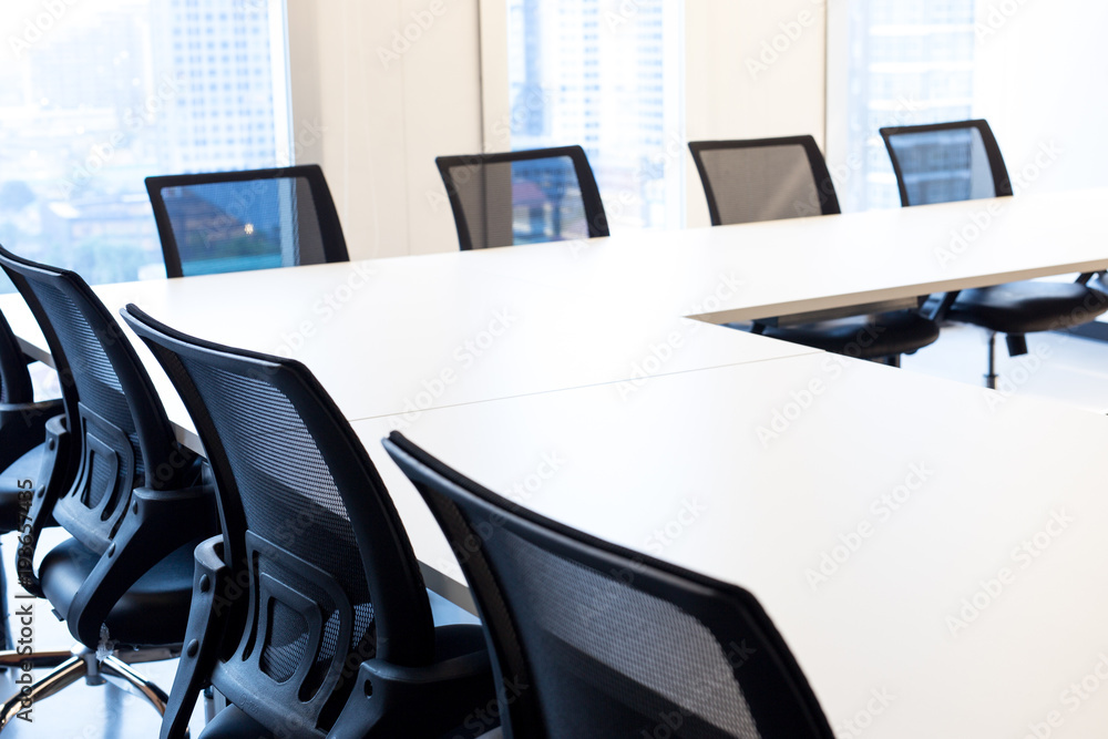 Modern meeting room with large windows, view back chair, outside building, city, tower view, soft focus. Modern meeting room with large windows, view back chair, outside building, city, tower view, soft focus.