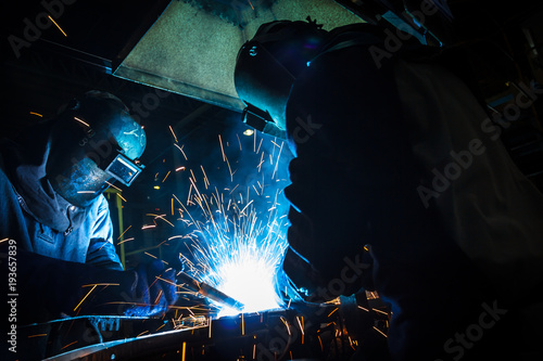 worker with protective mask welding metal