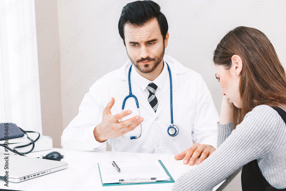 Doctor and woman patient consulting on doctors table in hospital.healthcare and medicine Doctor and woman patient consulting on doctors table in hospital.healthcare and medicine