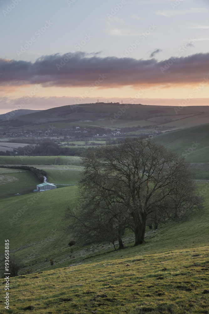 Stunning vibrant sunrise landscape image over English countryside landscape with lovely light hitting the hills