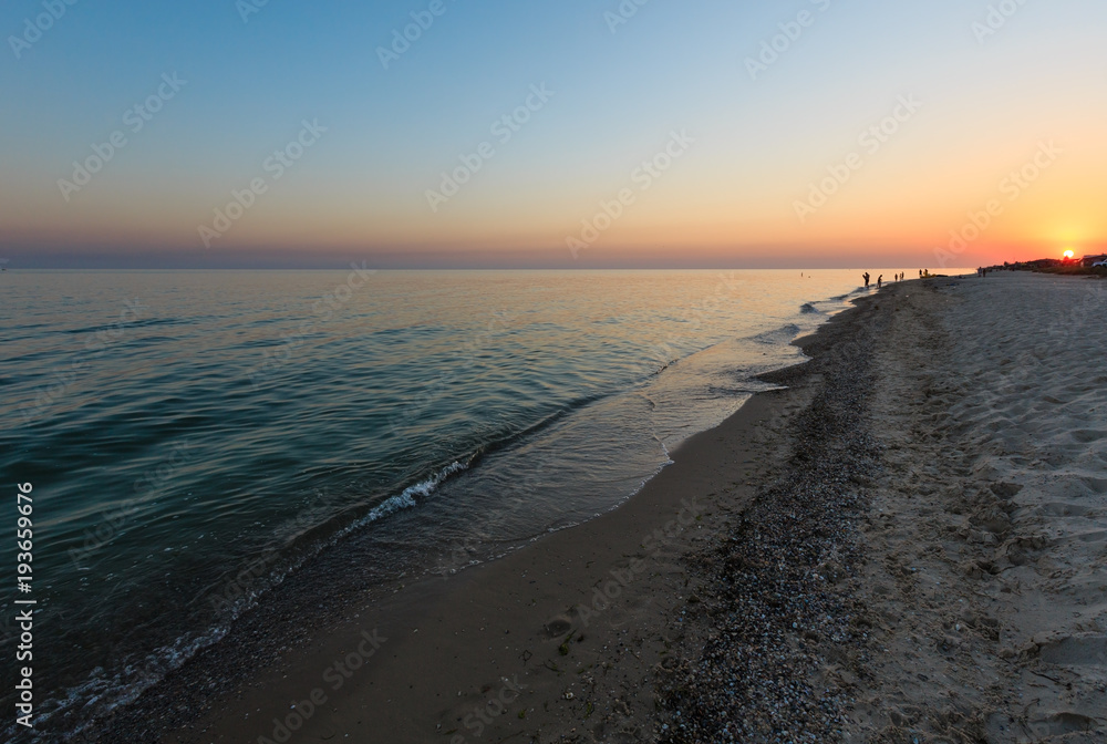 Sunset above camping on Azov sea sandy shore (Kherson Region, Ukraine)