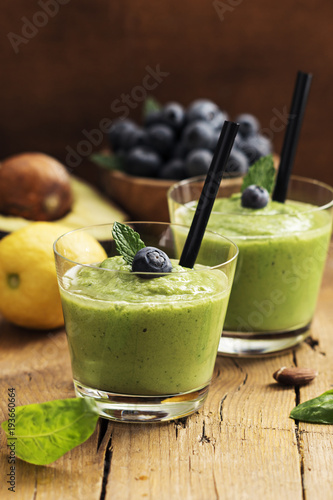 Smoothie recipe with green spinach, almond on  wooden board. Well being and weight loss concept.