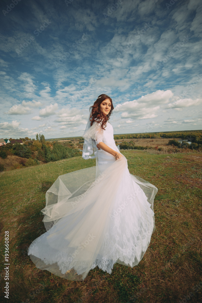 the bride is spinning in the field. flying dress