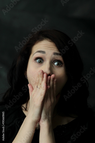 brunette girl covering her face with her hands