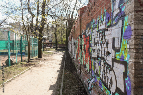 A path along the wall with graffiti. © German S