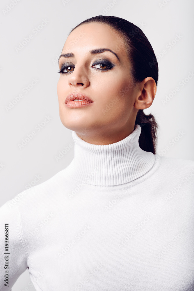 Young brunette woman wearing white poloneck in studio shot Young brunette woman wearing white poloneck in studio shot