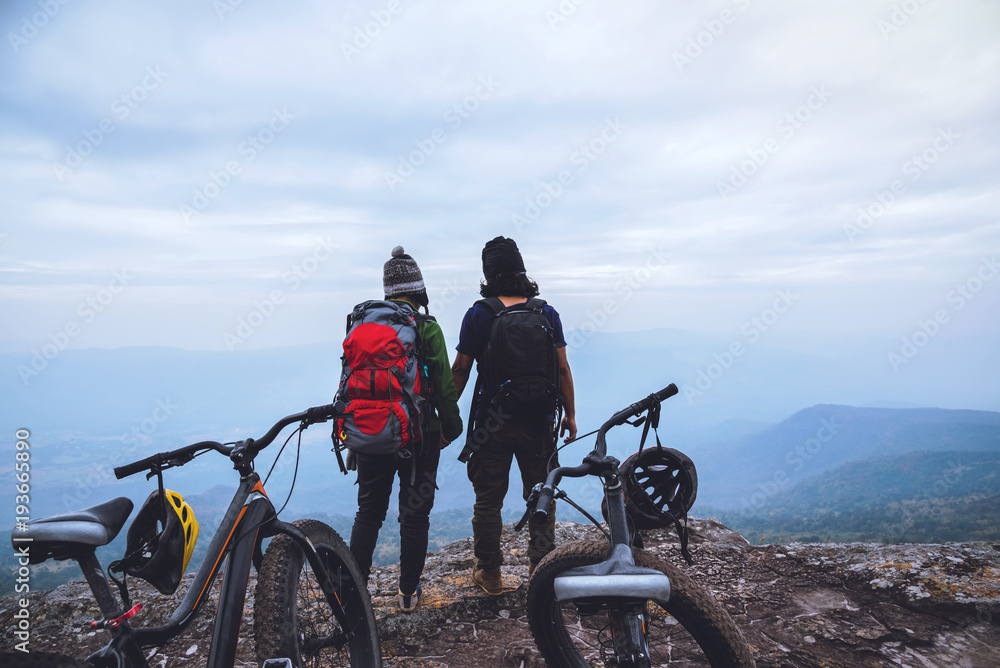  Asian lover women and men Travel Nature. Travel relax ride a bike Wilderness in the wild. Standing on a rocky cliff. Thailand