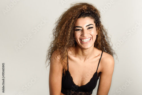 Young happy woman with curly hairstyle smiling