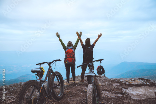  Asian lover women and men Travel Nature. Travel relax ride a bike Wilderness in the wild. Standing on a rocky cliff. Thailand