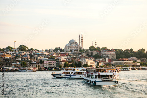 Boats sail along the Bosphorus on the background of beautiful views of Sambul at sunset.