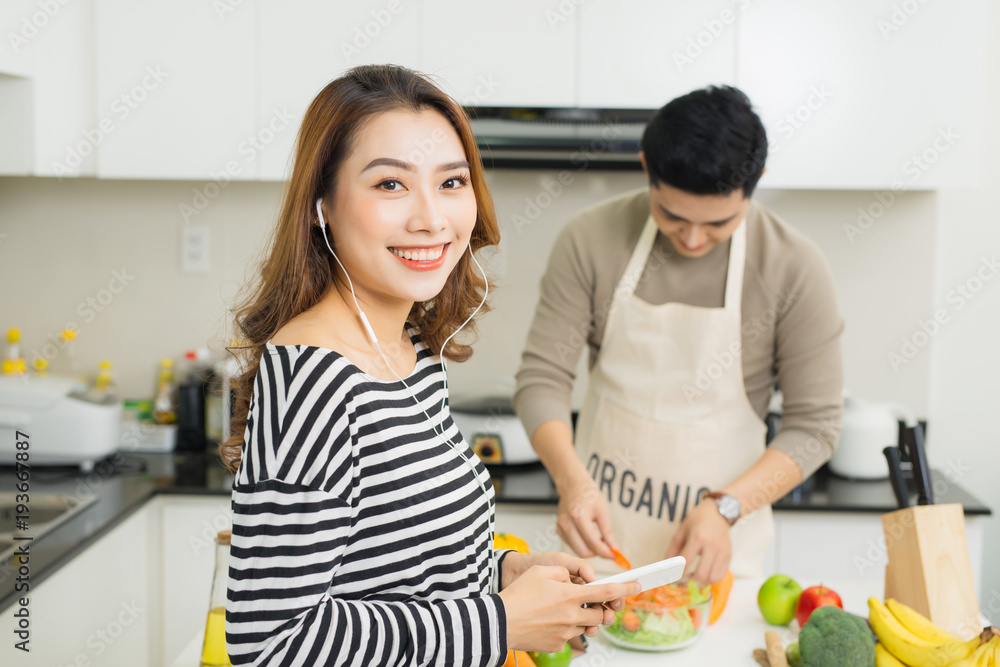 Asian wife waiting for food on a kitchen at home Asian wife waiting for food on a kitchen at home