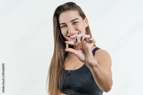 Supplements, Sports, Vitamins, Diet, Nutrition, Healthy Eating, Lifestyle. Close up of smiling fitness woman taking pill with cod liver oil Omega-3