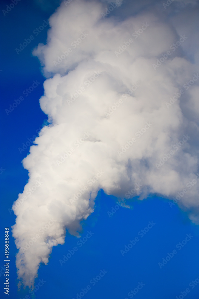 smoke from a pipe in the factory against a blue sky