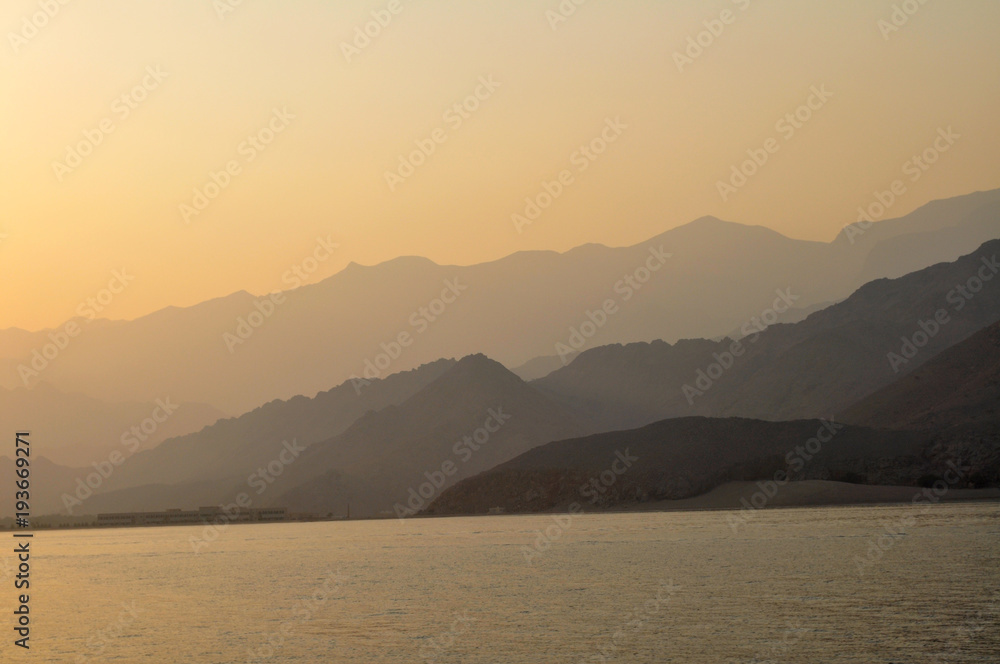 a magnificent sunset against the background of the mountain ranges of Oman