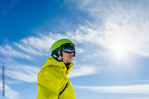 Photo of sporty man wearing mask and helmet against blue sky © nuclear_lily