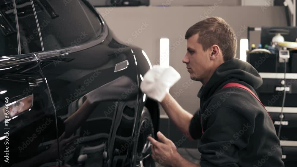 Finishing off cleaning process of a black new car. Finishing off cleaning process of a black new car.