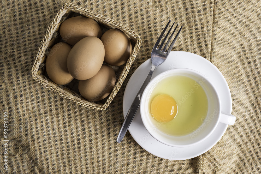 Fresh egg in white cup on cloth background. Fresh egg in white cup on cloth background.
