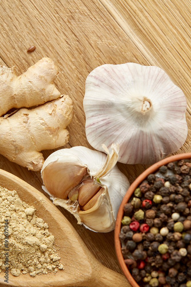 Composition of powder spices on spoon and different sorts of spicies on wooden table background, selective focus Composition of powder spices on spoon and different sorts of spicies on wooden table background, selective focus