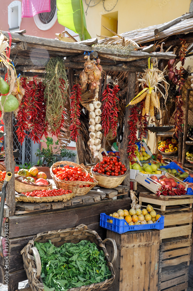 The island of Procida, Naples / Italy - September 18, 2017: rustic Italian market with organic vegetables and fruits, grapes and bunches of chili peppers