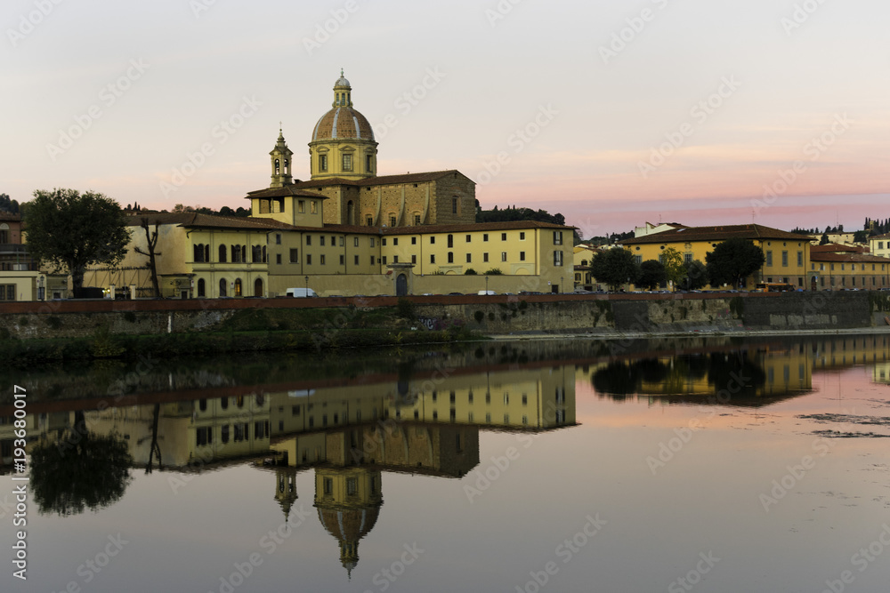 Florence, Tuscany / Italy Dawn on the Arno river embankment in the historical center, View of the church and yellow houses, reflection of the city Florence in the water
