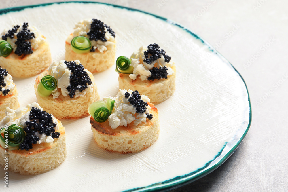 Tasty black caviar appetizer on plate