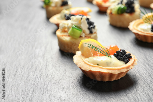 Billede på lærred Tasty black caviar appetizers on slate plate