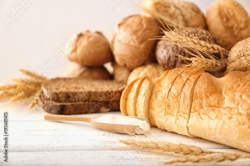 Freshly baked bread, flour and spikes on table