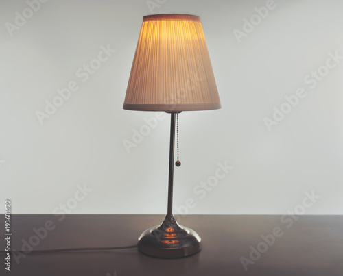 Stylish lamp on table against light background