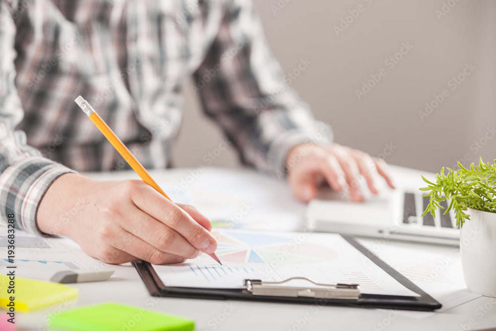 Businessman holding a pen is working with graph documents. Stock market chart and finger pointing on tablet in office. Businessman holding a pen is working with graph documents. Stock market chart and finger pointing on tablet in office.