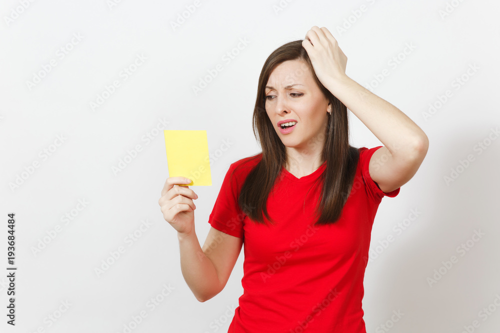 European upset crying shocked young woman, football fan or player in red uniform hold yellow soccer card for retire from field isolated on white background. Sport, play, healthy lifestyle concept. European upset crying shocked young woman, football fan or player in red uniform hold yellow soccer card for retire from field isolated on white background. Sport, play, healthy lifestyle concept.