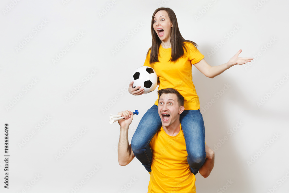 Inspired young couple, woman sit on man shoulders, fans with soccer ball pipe cheer favorite football team expressive gesticulate hands isolated on white background. Family leisure, lifestyle concept. Inspired young couple, woman sit on man shoulders, fans with soccer ball pipe cheer favorite football team expressive gesticulate hands isolated on white background. Family leisure, lifestyle concept.