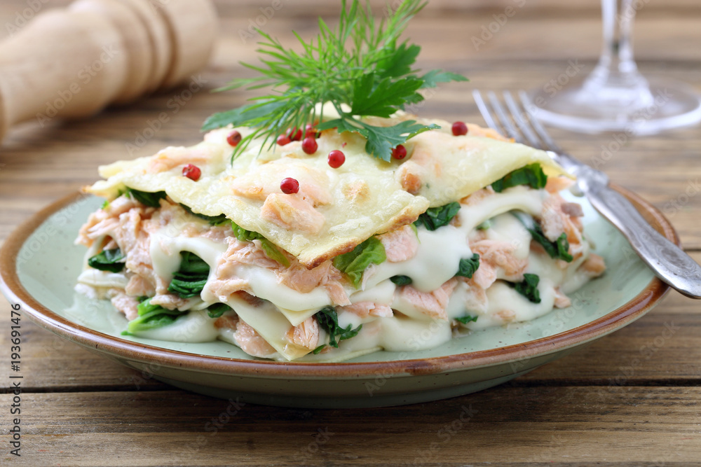 lasagne al forno con salmone e spinaci su sfondo rustico lasagne al forno con salmone e spinaci su sfondo rustico