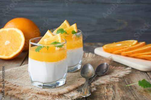 Panna cotta with orange jelly on a wooden table