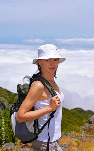 Young woman in mountains above the clouds.