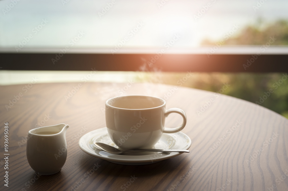 Hot coffee with milk on table in the morning time Hot coffee with milk on table in the morning time
