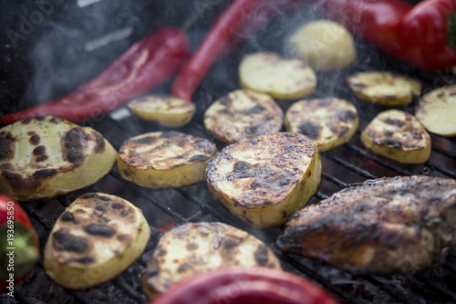 Hot Outdoor BBQ Grill With A Cut Potatoes Pieces, Red Peppers And Tasty Chicken Breast Meat