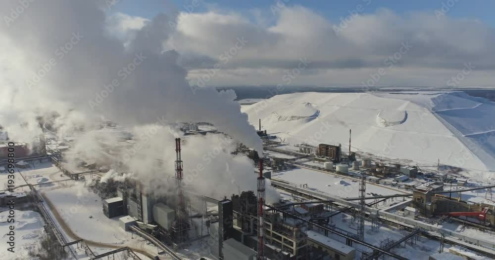 Aerial view of gas processing plant at winter time. Aerial view of factory smoke stack - Oil refinery, petrochemical or chemical plant in winter Aerial view of gas processing plant at winter time. Aerial view of factory smoke stack - Oil refinery, petrochemical or chemical plant in winter