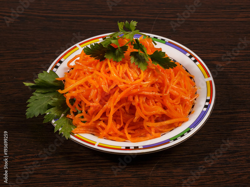 Carrots finely chopped and parsley on a plate on the table.