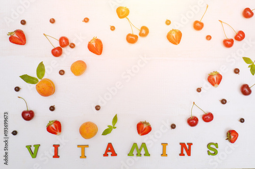 Fototapeta Naklejka Na Ścianę i Meble -  Color inscription Vitamins. Fruits and copy space.White background. Food concept