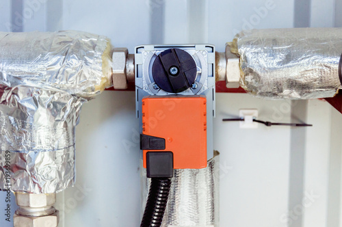Fotografie Orange damper actuator installed on the industrial ventilation unit body, front