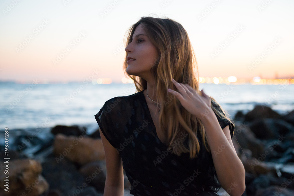 Young girl on the beach at sunset Young girl on the beach at sunset