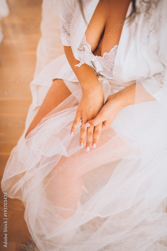 Bridal morning preparation. Wedding ring on bride's hand. Artwork. Selective focus on the wedding ring. Close-up