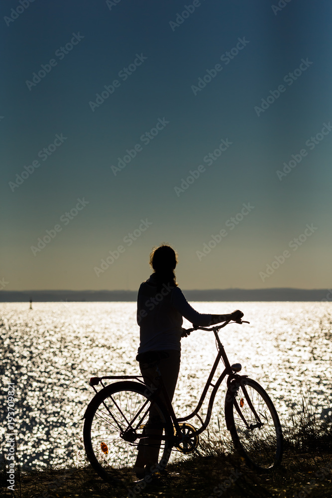 Fototapeta premium Woman relaxing with bike at seaside