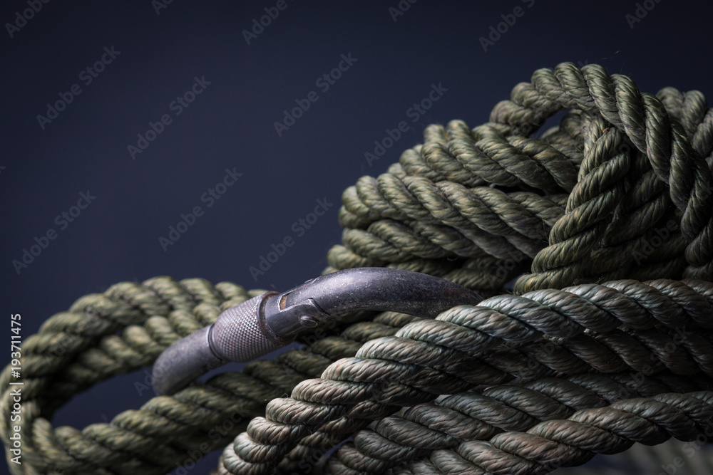 Green climbing rope coiled with carabiner