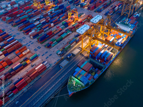 Aerial view of Containers yard in port congestion with ship vessels are loading and discharging operations of the transportation in international port.Shot from drone.