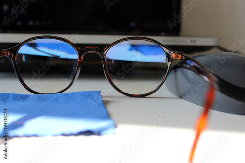 occhiali con riflesso blu sulla scrivania con computer 