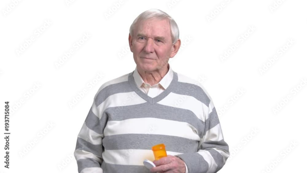 Senior man holding medicine, white background. Older man taking medicine, isolated on white background. Treatment of migraine by pills. Senior man holding medicine, white background. Older man taking medicine, isolated on white background. Treatment of migraine by pills.