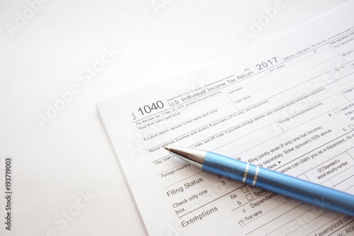 US 1040 tax return form and pen isolated on white background, taxation concept