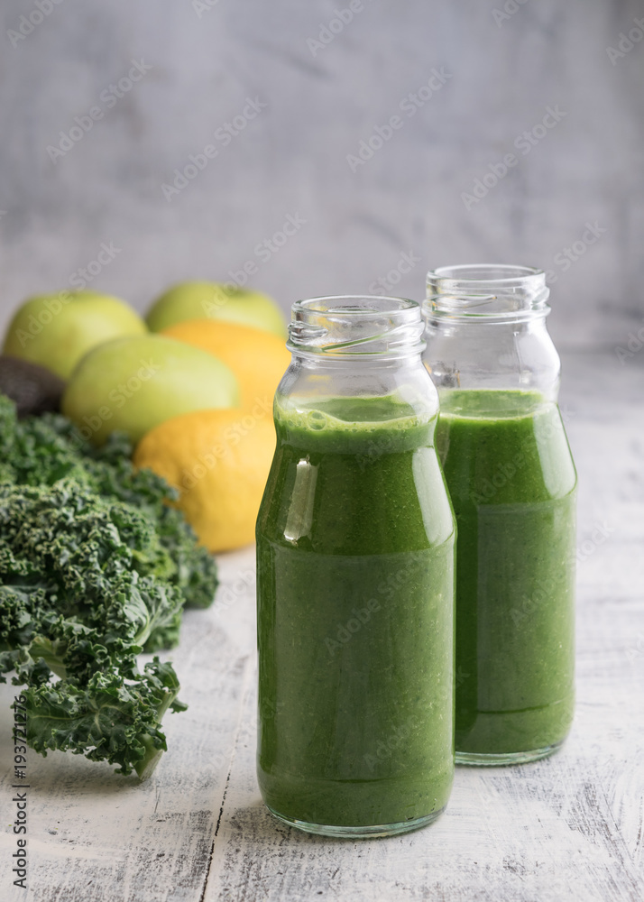 Healthy smoothie with kale in bottles on table Healthy smoothie with kale in bottles on table