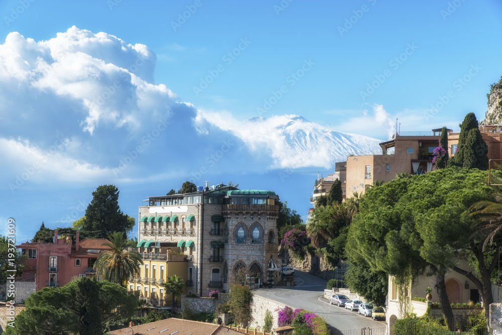 Beautiful ancient Taormina city with the volcano Etna at the background. Province of Messina. Sicily, Italy.